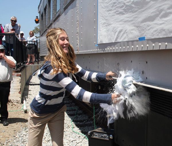 photo of dedication with breaking champagne on railcar